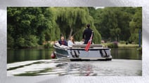 A couple enjoying a boat trip on the Thames River that runs alongside The Runnymede, a Warner Hotel. The border depicts the texture of a fluffy towel found within your cosy bedroom.