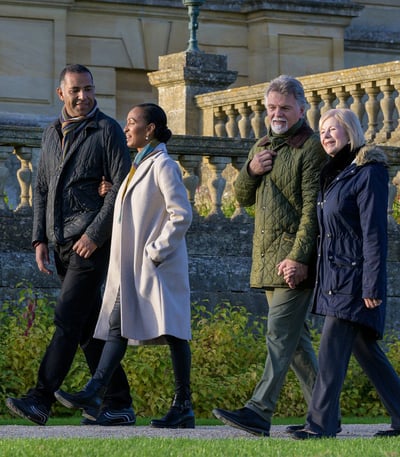 two couples walking with coats on, enjoying the gardens