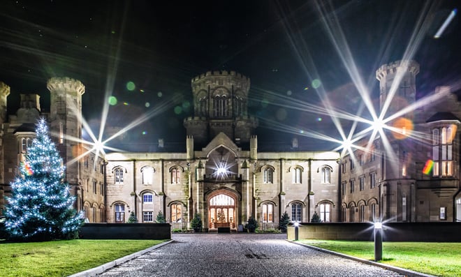 Studley Castle at night with a Christmas Tree in front of the castle